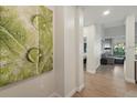 Inviting hallway featuring hardwood floors, stylish artwork, and a glimpse into the cozy living area, showcasing the home's modern design at 14501 Grove Resort Ave # 2103, Winter Garden, FL 34787