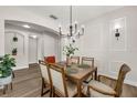 Bright dining room with modern chandelier and elegant wall detailing. Seats six at 14673 Tanja King Blvd, Orlando, FL 32828