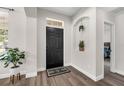 Inviting foyer with wood-look flooring, decorative niche, and access to other rooms at 14673 Tanja King Blvd, Orlando, FL 32828