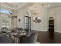 Elegant dining room features a modern table setting, stylish lighting, and dark hardwood floors at 1570 Westover Loop, Lake Mary, FL 32746