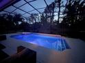 A beautifully lit screened-in pool at night, offering a serene and inviting atmosphere at 1570 Westover Loop, Lake Mary, FL 32746