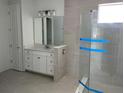 Elegant bathroom with a glass-enclosed shower, sleek vanity, tile flooring, and ample natural light at 16759 Muskgrass Dr, Winter Garden, FL 34787