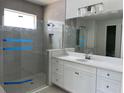 Stylish bathroom with a frameless shower, quartz vanity, tile flooring, and modern finishes at 16759 Muskgrass Dr, Winter Garden, FL 34787