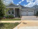Charming single-Gathering home featuring a two-car garage, well-manicured lawn, and inviting front porch at 16759 Muskgrass Dr, Winter Garden, FL 34787