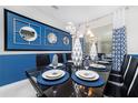 A stylish dining room featuring a large, black table set for a meal at 1781 Sawyer Palm Pl, Kissimmee, FL 34747