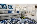 Comfortable living room featuring a gray couch with blue pillows and a stylish blue and white rug at 1781 Sawyer Palm Pl, Kissimmee, FL 34747