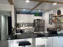 Modern kitchen boasts sleek stainless steel appliances, white cabinetry, breakfast bar, and unique brick backsplash at 1935 Conway Rd # T6, Orlando, FL 32812