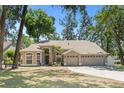 Inviting single-story home featuring a spacious three-car garage, lush green lawn, and meticulously maintained landscaping at 2082 Nexus Ct, Apopka, FL 32712