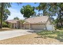 Traditional home with three-car garage, well-maintained lawn, and a welcoming front entrance at 2082 Nexus Ct, Apopka, FL 32712