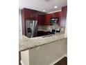 Kitchen featuring granite countertops, stainless steel appliances, and wood cabinets at 2164 Black Mangrove Dr, Orlando, FL 32828