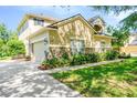 Exterior shot of home, showing well-maintained lawn, stone accents and a spacious driveway leading to a two-car garage at 2401 Home Again Rd, Apopka, FL 32712