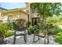 Close up of front exterior showing a charming seating area surrounded by lush vegetation and a stone facade at 2401 Home Again Rd, Apopka, FL 32712
