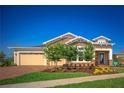 Inviting home featuring a brick driveway, manicured lawn, and an attached three-car garage at 2460 Dream Home Ct, St Cloud, FL 34772