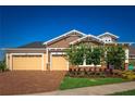 Beautiful single-Gathering home featuring a brick driveway, three-car garage, and manicured landscaping at 2460 Dream Home Ct, St Cloud, FL 34772
