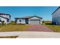 Inviting single-story home featuring a brick driveway and a well-manicured lawn at 264 Towns Cir, Haines City, FL 33844