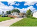 Well-kept home featuring a wheelchair ramp, covered carport, and lush landscaping at 2650 Einwood Dr, Kissimmee, FL 34758