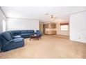 Cozy living room featuring carpeted floors, natural light, and a blue sectional sofa at 2650 Einwood Dr, Kissimmee, FL 34758