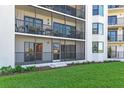 Exterior condo view featuring a screened balcony, lush greenery, and well-maintained landscaping at 2700 N Peninsula Ave # 215, New Smyrna Beach, FL 32169