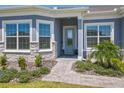 Inviting front entrance with stone accents, lush landscaping, and a stylish glass-paneled door at 3182 Sailing Pier Ave, Winter Garden, FL 34787