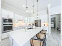 Modern kitchen featuring white cabinets, stainless steel appliances, and a large center island with seating at 3182 Sailing Pier Ave, Winter Garden, FL 34787