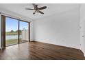 Bright bedroom features modern ceiling fan, wood-look flooring, and large sliding glass door at 3462 Allegra Cir, St Cloud, FL 34772