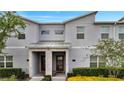 Charming townhome with modern facade, brick accents, a covered entry, and professionally landscaped front yard at 368 Ocean Course Ave, Davenport, FL 33896