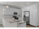 Modern kitchen featuring stainless steel appliances, granite countertops, and ample white cabinet space at 3723 Broadway St, Gotha, FL 34734