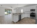 Modern kitchen with stainless steel appliances, white cabinets, granite countertops, and an open floor plan at 3723 Broadway St, Gotha, FL 34734