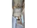 Stunning entryway featuring high ceilings, a modern chandelier, and wood-look tile flooring at 402 Cool Summer Ln, Davenport, FL 33837