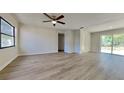 Open living room with laminate floors, fresh paint and a sliding glass door to the backyard at 4510 Ravinnia Dr, Orlando, FL 32809