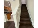 Dark wood staircase leading to the upper level, open to the kitchen at 8271 Maritime Flag St # 125, Windermere, FL 34786