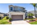 Two-story home with a two-car garage, well-manicured lawn, and tropical landscaping, offering curb appeal at 918 Emerald Green Ct, Kissimmee, FL 34746