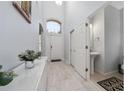Bright foyer boasts high ceilings, tile floors, and a view of the front door and a conveniently located half-bath at 918 Emerald Green Ct, Kissimmee, FL 34746