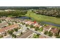 Stunning aerial view of home nestled on a manicured golf course with a serene lake at 9895 Winnington St, Orlando, FL 32832