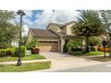 Inviting two-story home boasting lush landscaping, a paved driveway, and a two-car garage at 9895 Winnington St, Orlando, FL 32832