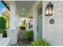 Inviting front porch with brick flooring, white pillars, and a vibrant green front door at 1114 Georgia Blvd, Orlando, FL 32803