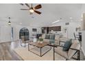 Open-concept living room with high ceilings, neutral furniture, and wood-look floors, filled with natural light at 1201 Groveland Dr, Chuluota, FL 32766