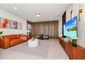 Bright living room with modern decor, stylish furniture, and a large television at 1293 Emerald Row, Clermont, FL 34714