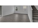 Bright living room with gray wood-look flooring and access to the upper floor via stairs at 1343 Wood Line Dr, Deland, FL 32720