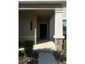 Inviting front porch with stone accents on the support beam and prominent house numbers at 14143 Title Way, Winter Garden, FL 34787