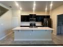Stylish kitchen with black cabinets, stainless steel appliances, and a large center island with seating at 14143 Title Way, Winter Garden, FL 34787