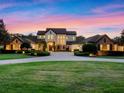 Elegant home featuring a manicured lawn, brick driveway, and beautifully landscaped grounds during twilight at 1526 Bluewater Run, Chuluota, FL 32766