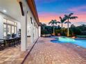 Covered patio with outdoor dining overlooking a beautiful pool and lush tropical landscaping at 1526 Bluewater Run, Chuluota, FL 32766