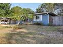 Charming single-story home with a well-manicured lawn, blue paint, and mature trees at 1656 Brentlawn St, Deltona, FL 32725