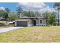 Attractive single-story home with a gray exterior, well-kept lawn, and a two-car attached garage at 1686 17Th St, Orange City, FL 32763