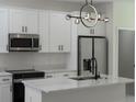 Modern kitchen boasts white cabinets, stainless steel appliances, and a stylish island with a black faucet at 1686 17Th St, Orange City, FL 32763