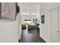 Bright hallway with modern dark wood floors leading to a living area with natural light from the sliding glass door at 1963 Thompson Preserve Blvd, Bartow, FL 33830