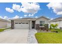Attractive one-story house featuring a two-car garage, stone details, and meticulously maintained landscaping at 236 Pink Ibis Bnd, St Cloud, FL 34772