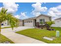 Well-maintained front yard with palm trees, stone accents, and green grass enhancing curb appeal at 236 Pink Ibis Bnd, St Cloud, FL 34772