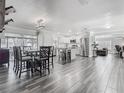 Open-concept living area featuring a modern kitchen, dining area, and wood-look tile flooring at 2817 Prince John Rd, Winter Park, FL 32792